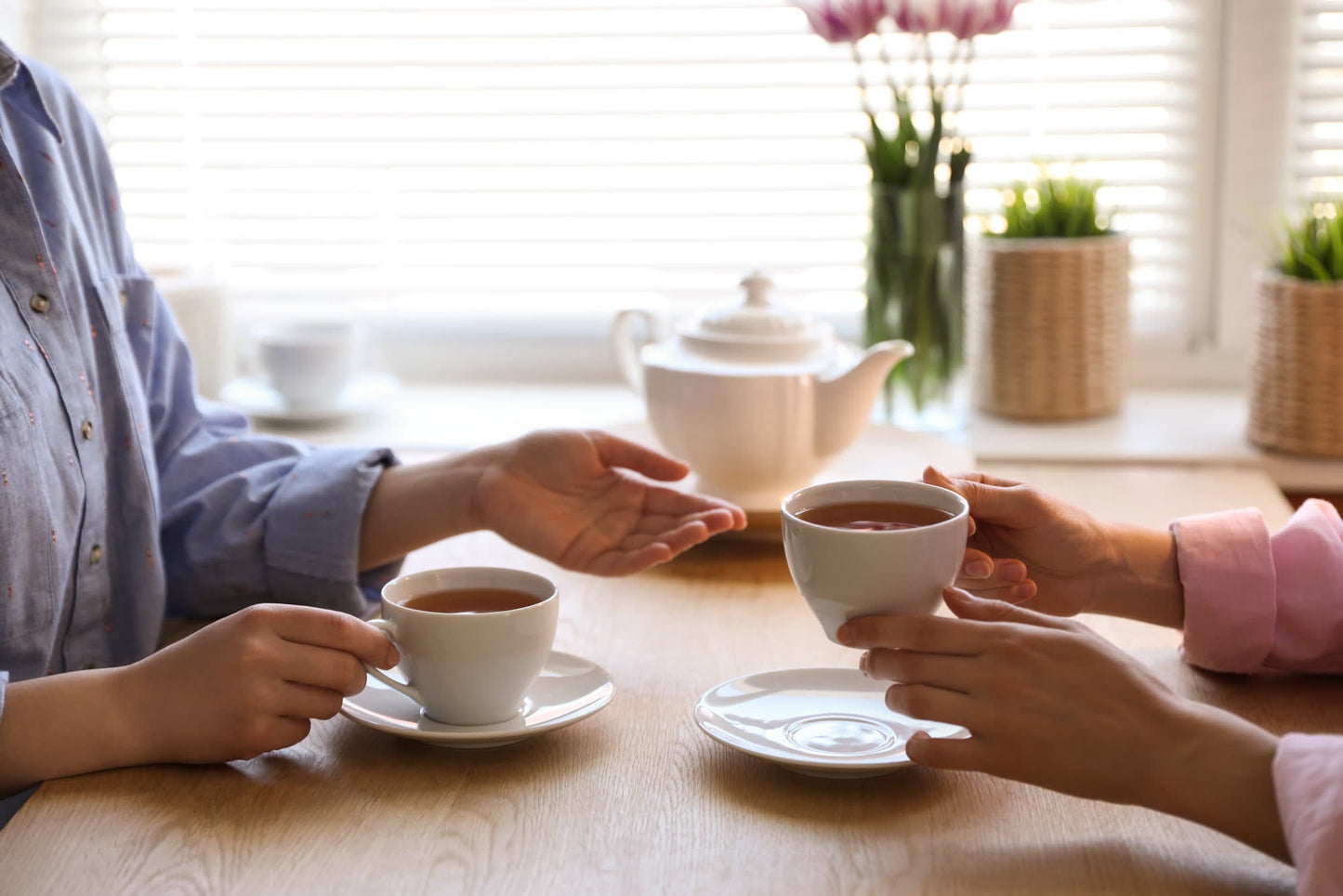 Two people sharing tea and conversation at a table