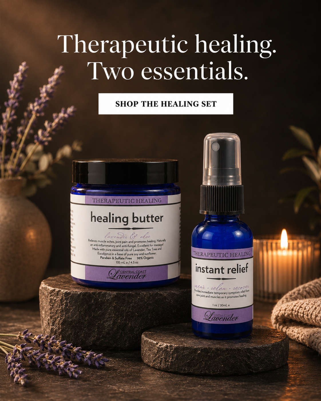 Marketing poster with burned in text on a dark background. The headline reads Therapeutic healing. Two essentials. A white button below it reads SHOP THE HEALING SET. A Central Coast Lavender Healing Butter jar and Instant Relief spray stand on dark stone plinths with lavender sprigs, a lit candle and a knitted throw.